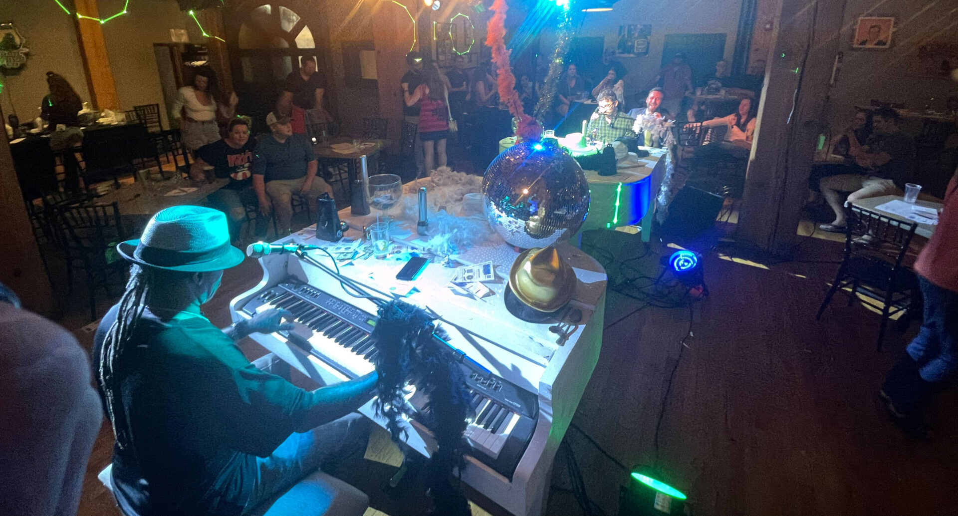 A group of people sitting around a table with a piano.