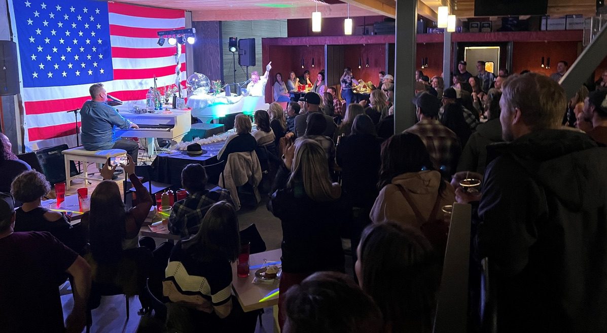 Dueling pianos entertaining a crowd for a fundraiser in Bozeman, MT.